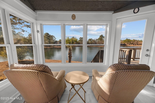 sunroom / solarium featuring a water view