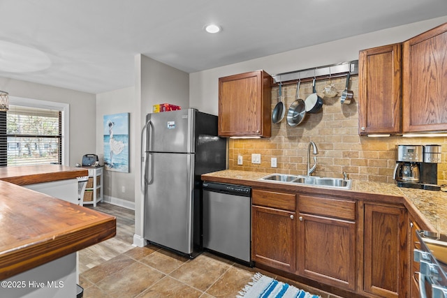 151 NE 9th St, Oak Island, NC 28465 - kitchen with appliances with stainless steel finishes, a sink, wood counters, backsplash, and baseboards