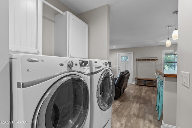151 NE 9th St, Oak Island, NC 28465 - washroom with washer and clothes dryer, cabinet space, and wood finished floors