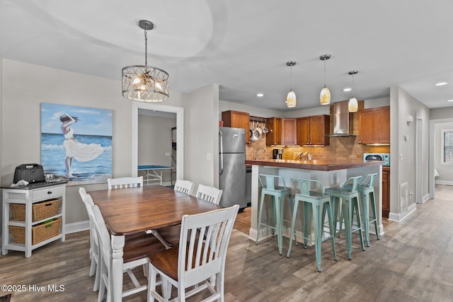 151 NE 9th St, Oak Island, NC 28465 - dining area with wood finished floors, recessed lighting, baseboards, and a chandelier