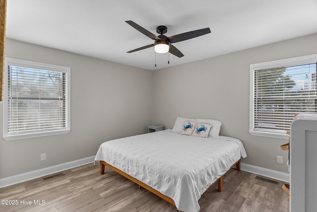 151 NE 9th St, Oak Island, NC 28465 - bedroom with wood finished floors, baseboards, and ceiling fan