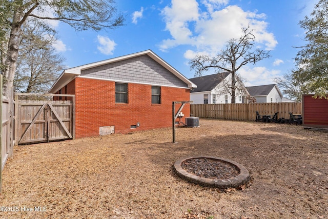 151 NE 9th St, Oak Island, NC 28465 - back of property with brick siding, crawl space, a gate, a fenced backyard, and central AC