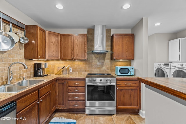 151 NE 9th St, Oak Island, NC 28465 - kitchen with appliances with stainless steel finishes, a sink, wall chimney exhaust hood, independent washer and dryer, and brown cabinets