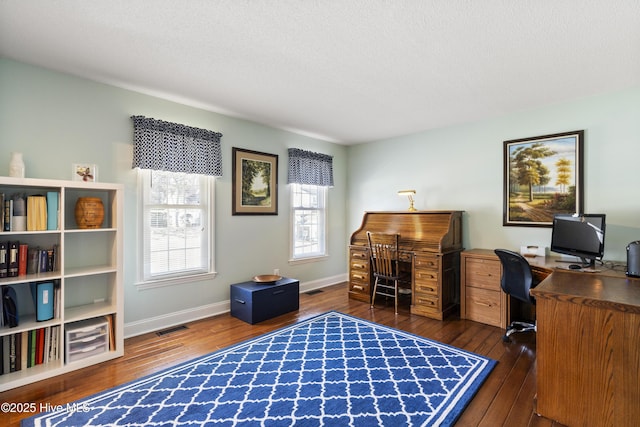 office featuring dark wood-type flooring, visible vents, and baseboards