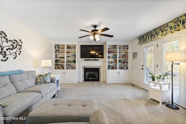 living area featuring carpet floors, a fireplace, and ceiling fan