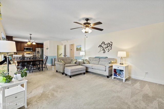 living room featuring ceiling fan, baseboards, and light colored carpet