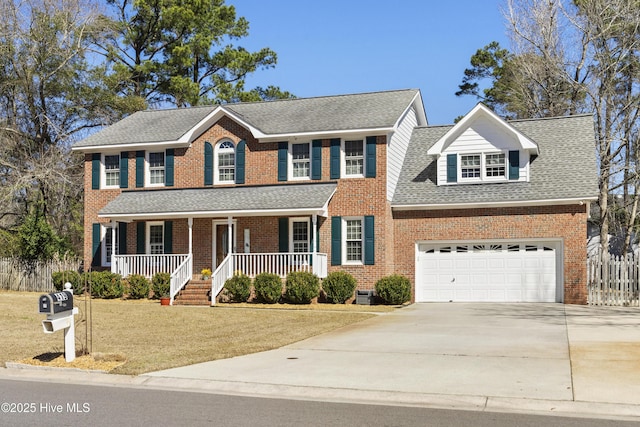 colonial home with an attached garage, covered porch, brick siding, driveway, and a front lawn