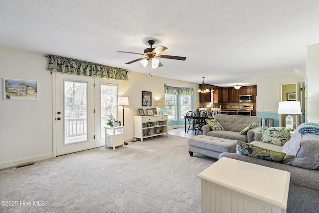 living room with light colored carpet, a textured ceiling, and baseboards