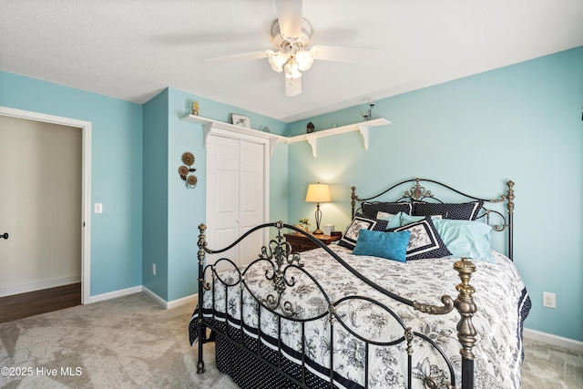 carpeted bedroom with a ceiling fan, baseboards, and a closet