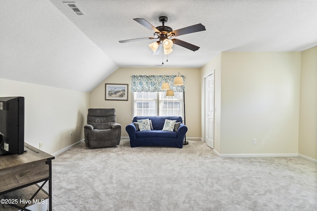 sitting room with carpet floors, baseboards, vaulted ceiling, and a textured ceiling