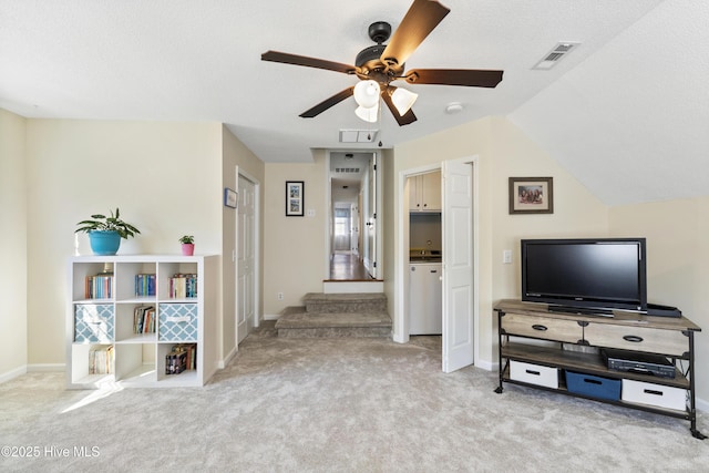 living area featuring visible vents, baseboards, ceiling fan, carpet, and stairs