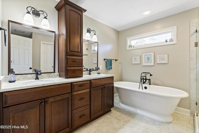 full bath with tile patterned flooring, a freestanding bath, a sink, and double vanity