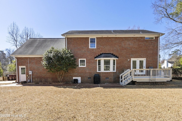 back of property with a deck, central AC unit, brick siding, crawl space, and a lawn