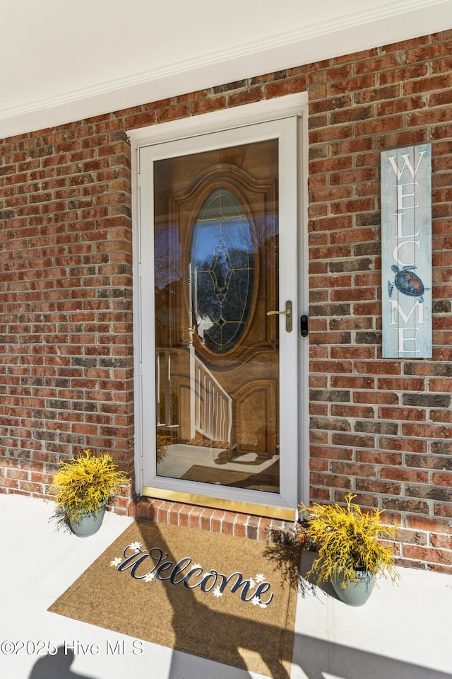 property entrance featuring brick siding