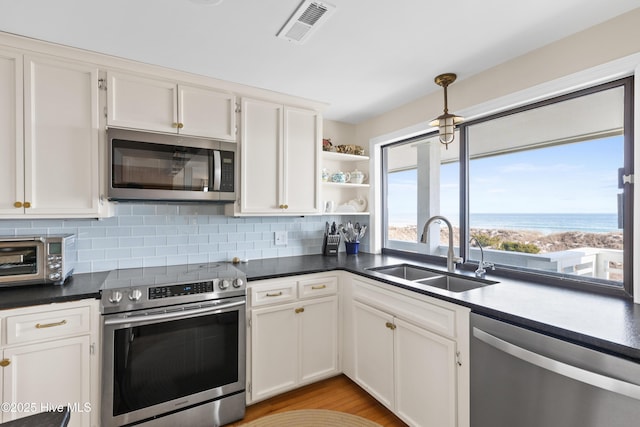 kitchen featuring a toaster, visible vents, white cabinets, stainless steel appliances, and a sink