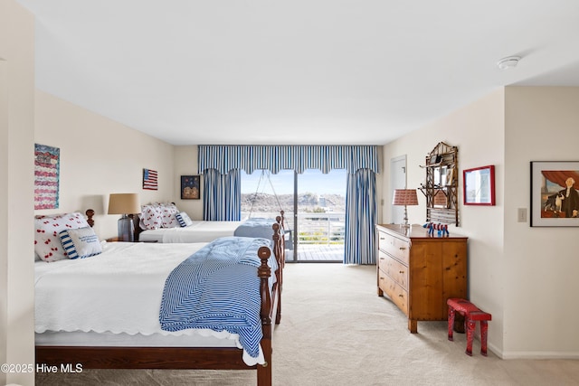 bedroom featuring light carpet, access to outside, and baseboards