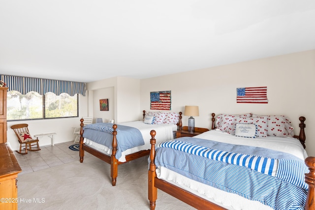 bedroom with light tile patterned floors and light colored carpet