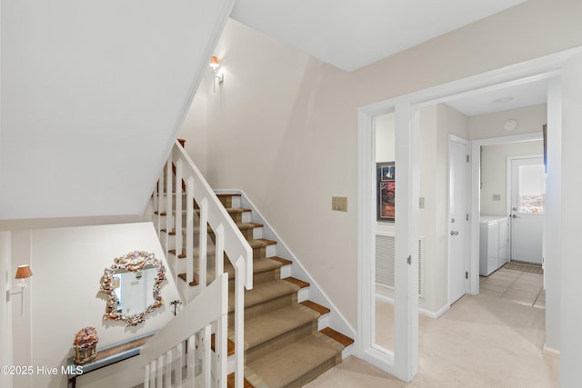 stairs with carpet, washing machine and dryer, visible vents, and baseboards