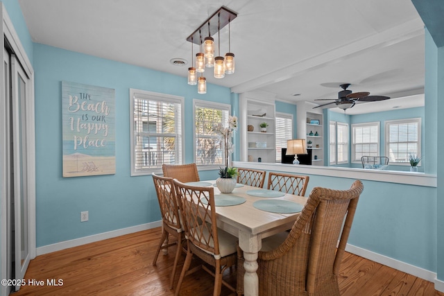 dining area with built in shelves, visible vents, ceiling fan, wood finished floors, and baseboards