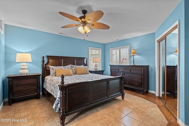 bedroom featuring ceiling fan, light tile patterned floors, visible vents, baseboards, and a closet