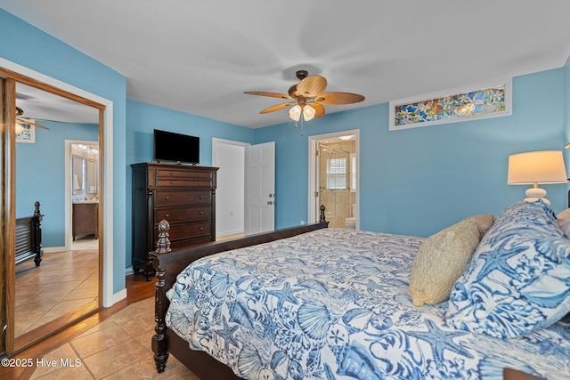 bedroom featuring baseboards, tile patterned flooring, ensuite bath, and ceiling fan