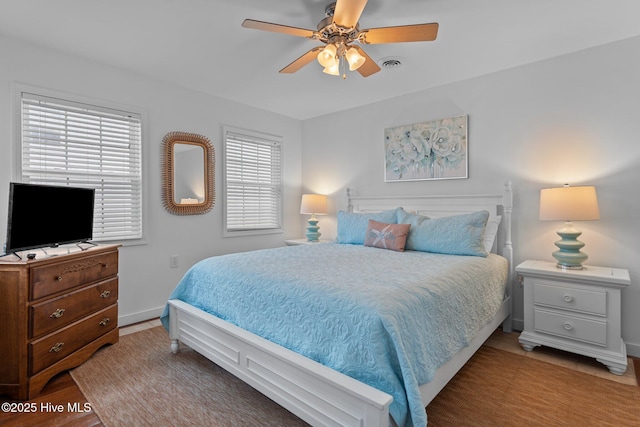 bedroom featuring light wood-type flooring, baseboards, visible vents, and ceiling fan