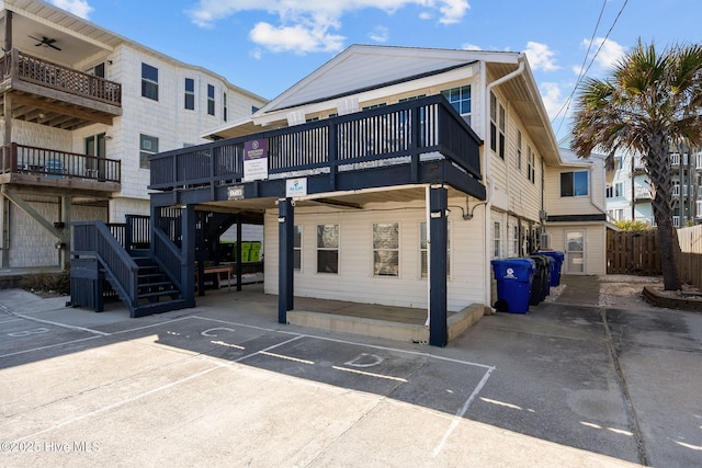 rear view of house with uncovered parking and a balcony