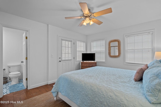 bedroom featuring a ceiling fan, baseboards, wood finished floors, and ensuite bathroom