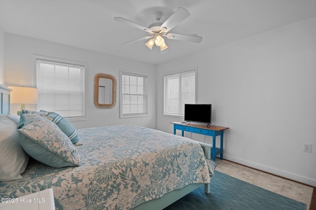 tiled bedroom featuring ceiling fan and baseboards