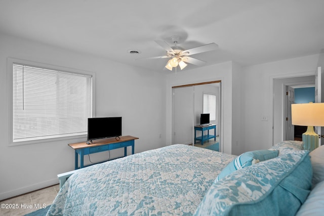 tiled bedroom with baseboards, ceiling fan, visible vents, and a closet