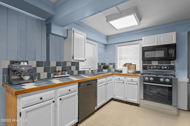 kitchen featuring black appliances, light floors, tile counters, and white cabinetry