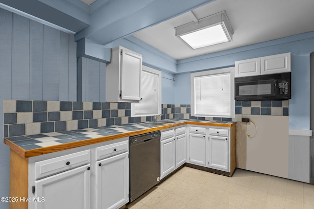 kitchen with tile counters, decorative backsplash, white cabinets, light floors, and black appliances