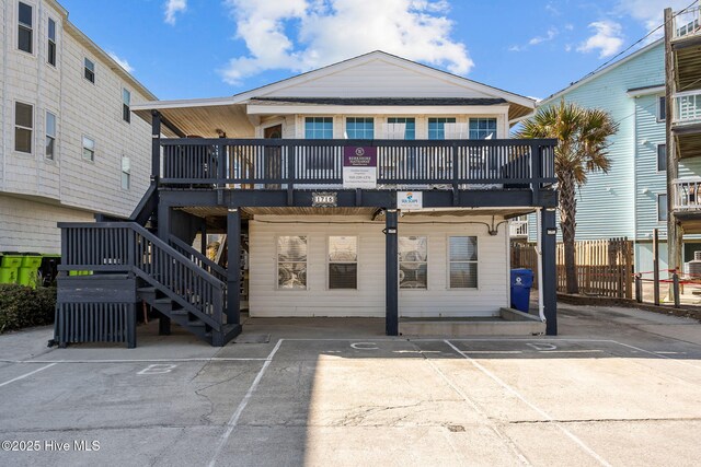 rear view of house with stairs, a deck, and fence