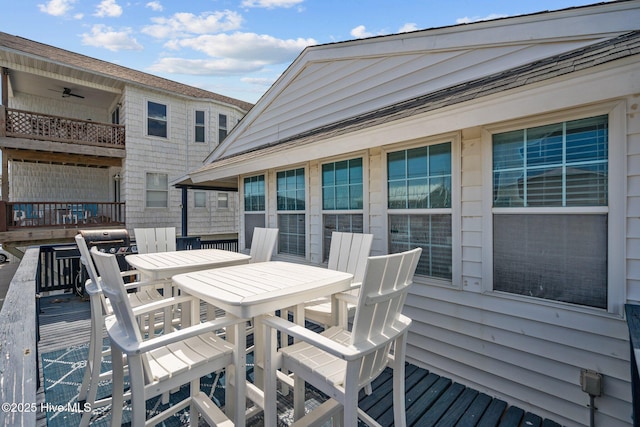 wooden terrace with ceiling fan and outdoor dining area