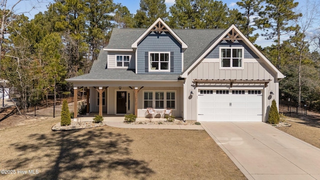 view of front of house featuring a porch, concrete driveway, board and batten siding, fence, and a garage