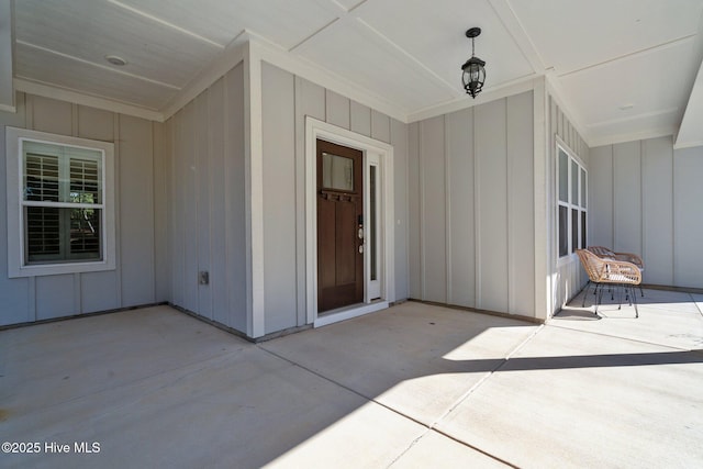 doorway to property featuring board and batten siding and a patio