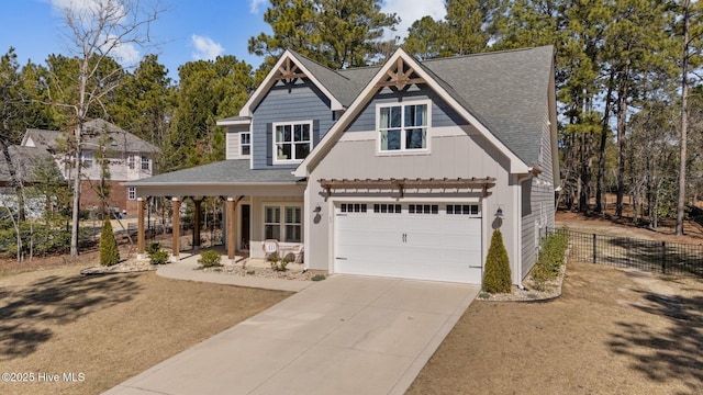 view of front of house with covered porch, a shingled roof, fence, driveway, and board and batten siding