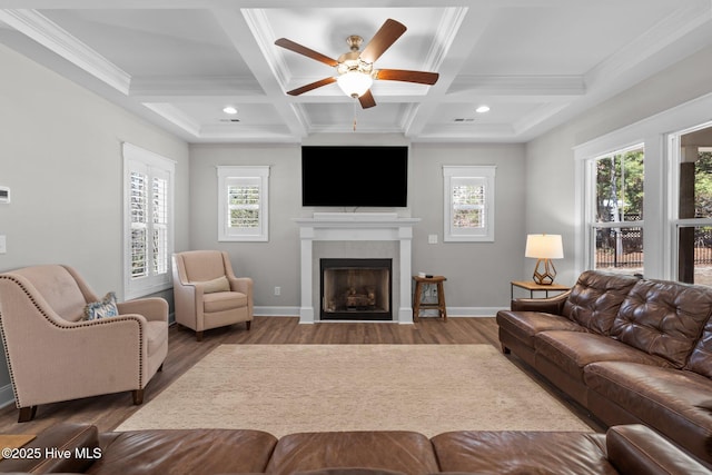 living room with a fireplace with flush hearth, beam ceiling, baseboards, and wood finished floors