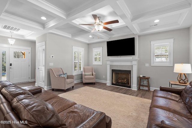 living area featuring beamed ceiling, a fireplace, wood finished floors, and visible vents