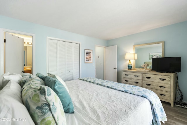 bedroom with a closet, wood finished floors, and connected bathroom