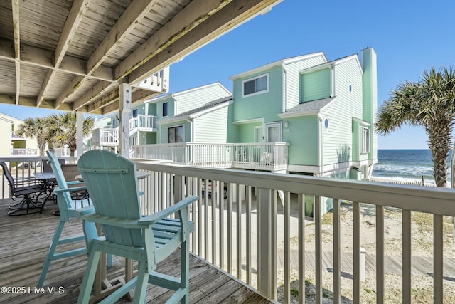 wooden terrace with a view of the beach and a water view