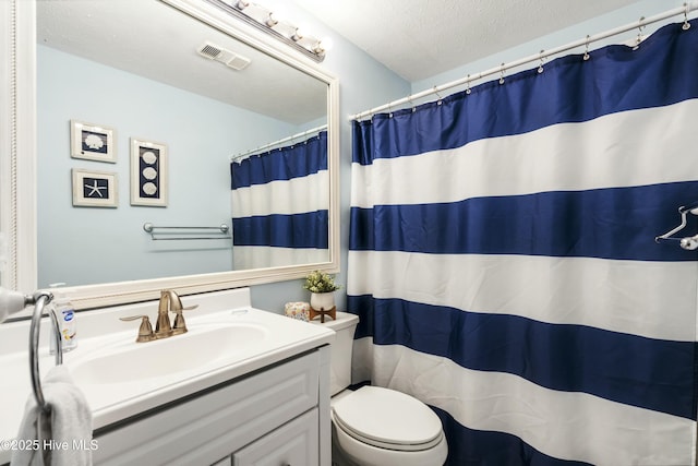 bathroom featuring visible vents, toilet, vanity, a textured ceiling, and a shower with curtain