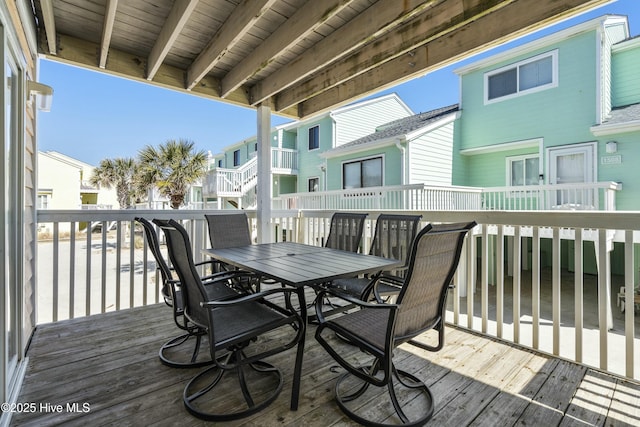 wooden deck with a residential view and outdoor dining space