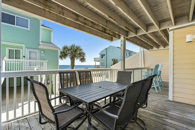 deck with outdoor dining area and a water view