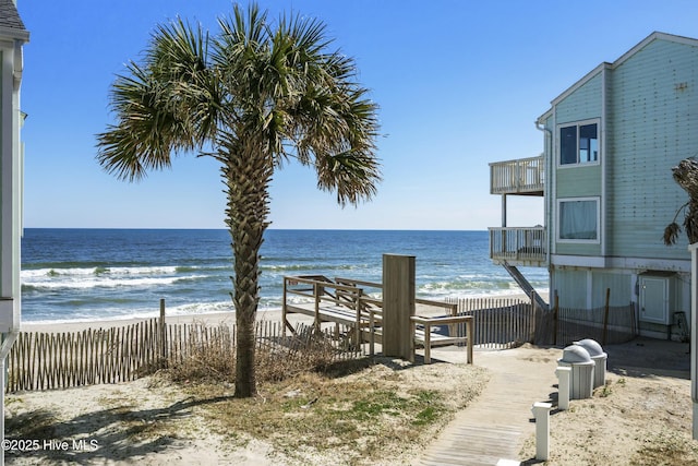 water view featuring fence and a view of the beach