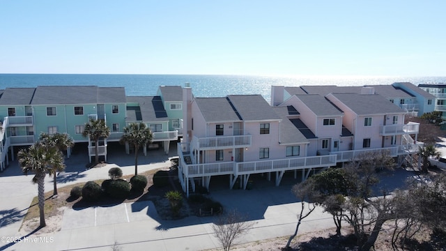 view of property with driveway, a water view, and a residential view