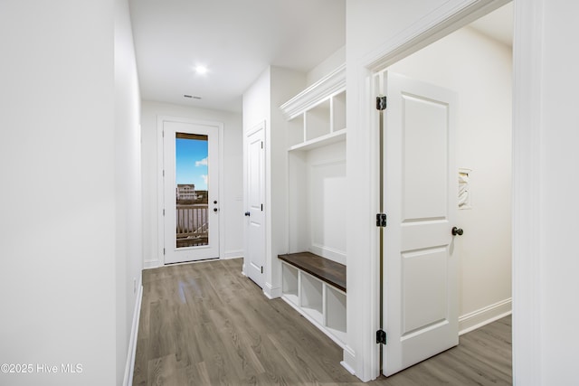 mudroom featuring visible vents, baseboards, and wood finished floors