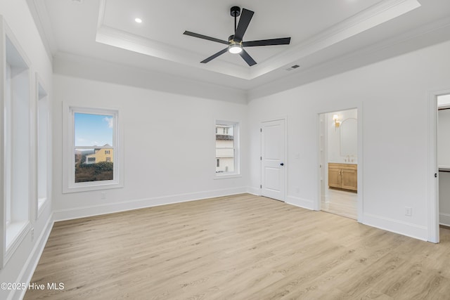 unfurnished bedroom with light wood-style floors, a raised ceiling, visible vents, and crown molding