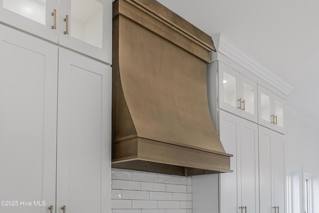 room details featuring custom exhaust hood and decorative backsplash