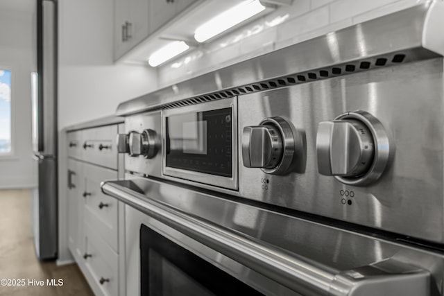 kitchen featuring stainless steel appliances and white cabinetry